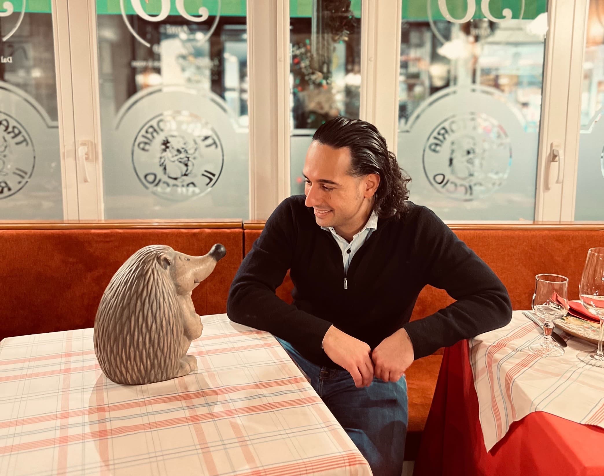 Luca attablé à Il Riccio, face au hérisson en céramique de la trattoria.