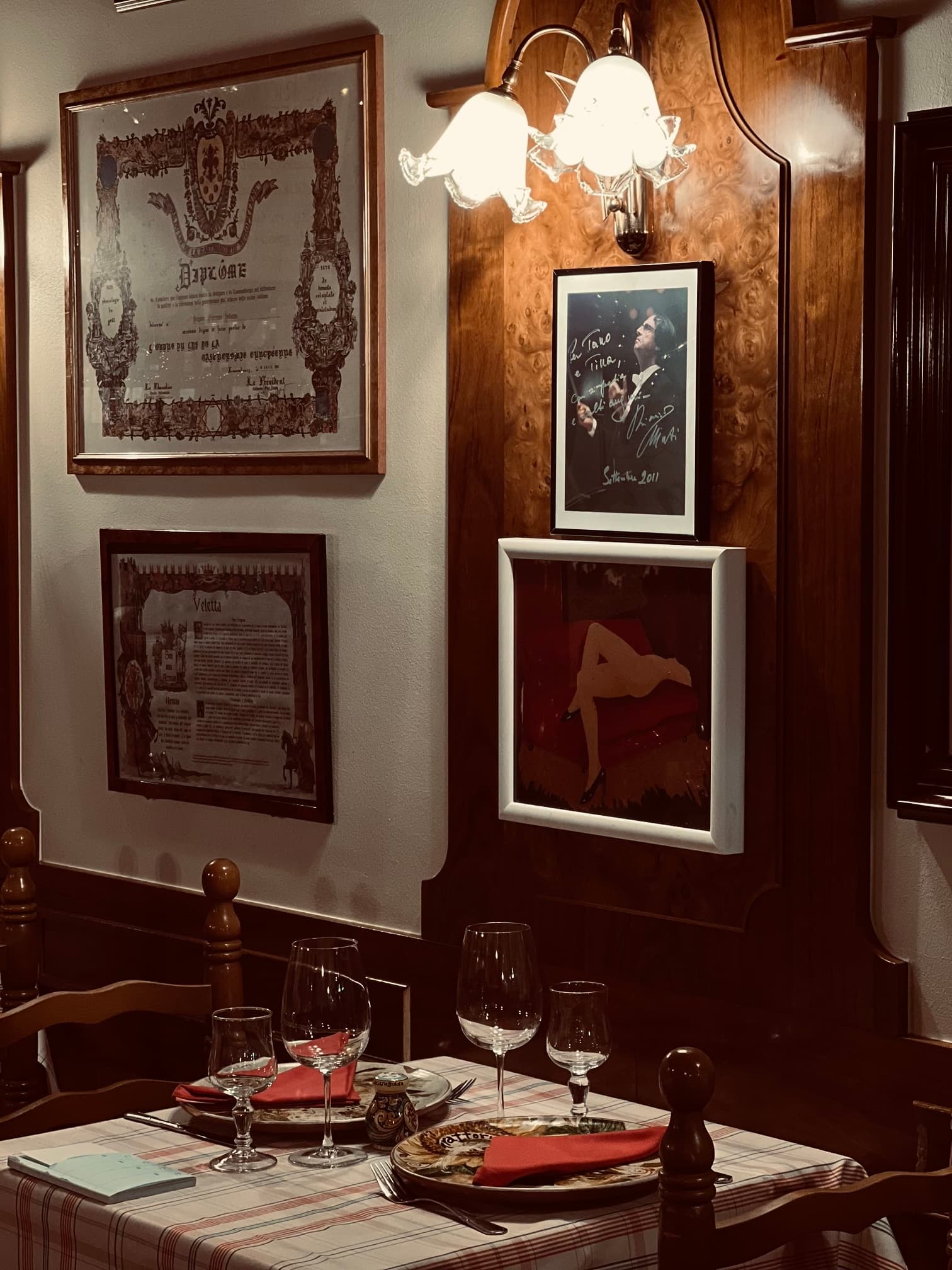 Une table dressée d’Il Riccio sous les diplômes encadrés et les photos dédicacées accumulés en trente ans.