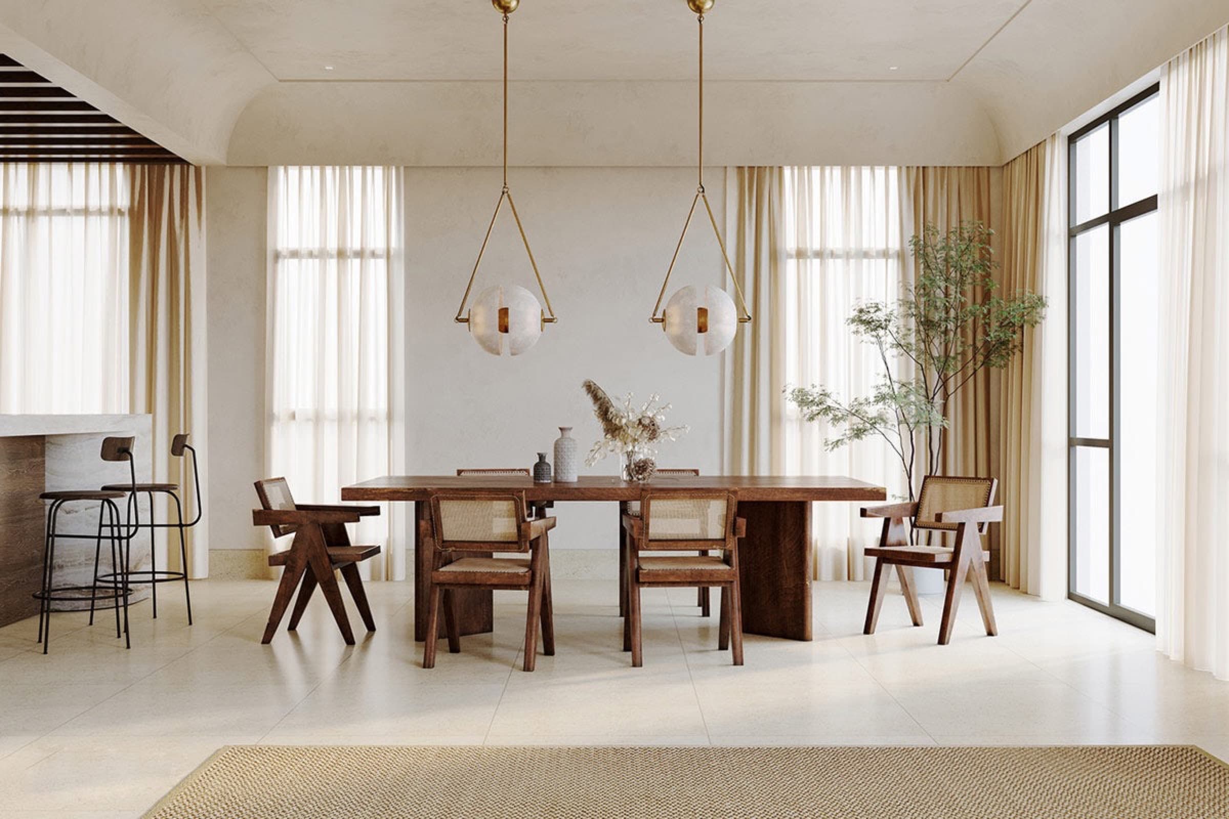 Salle à manger meublée de chaises en cannage Pierre Jeanneret et d’une table en noyer.